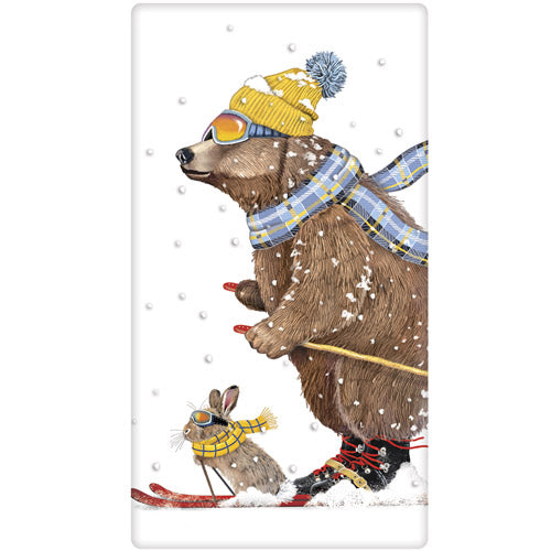 Tea towel with design of a bear and rabbit skiing together with snowflakes falling.