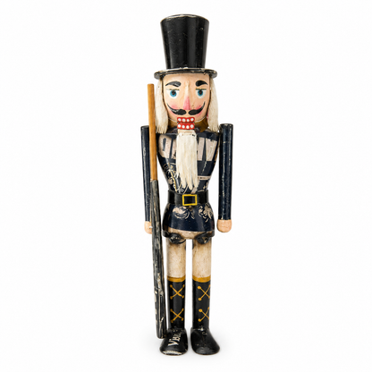 Nutcracker figurine with a top hat and a staff on a white background