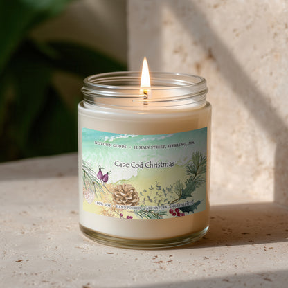 Clear jar candle with white wax and a decorative label on a blurred outdoor background.