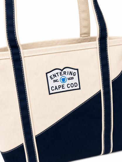 Navy and beige tote bag with a logo on a white background
