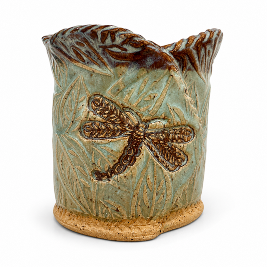 Ceramic candle with dragonfly design on a white background