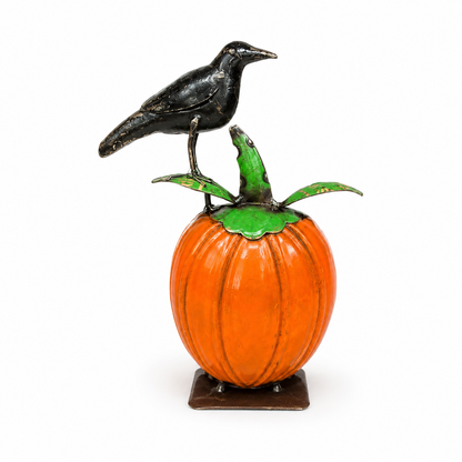 Decorative pumpkin with a crow on top on a white background