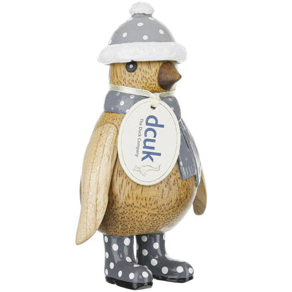 Decorative penguin figurine wearing a hat, scarf, and boots with a visible brand tag on a white background.