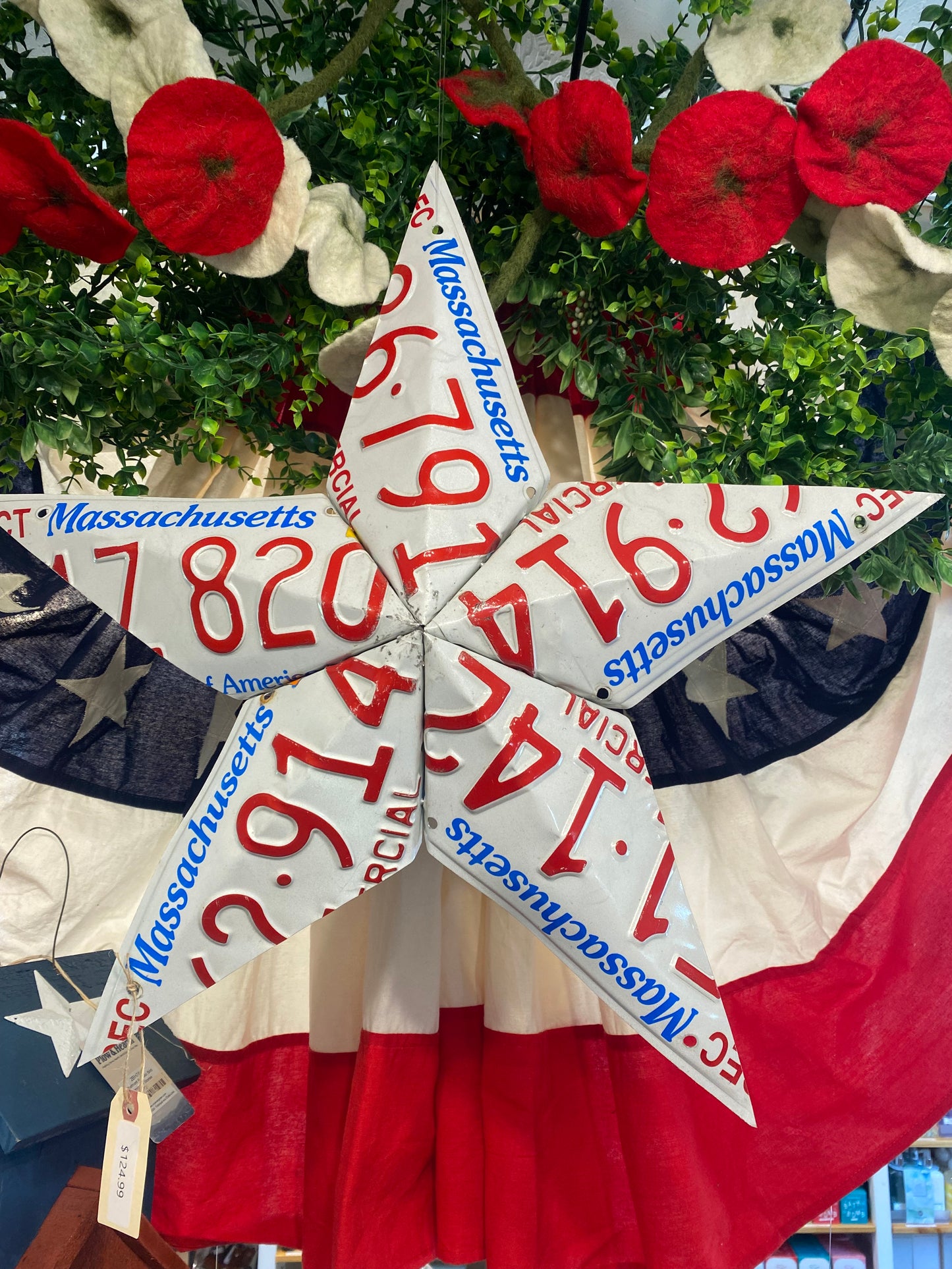 Decorative star with Massachusetts license plates and American flag background.