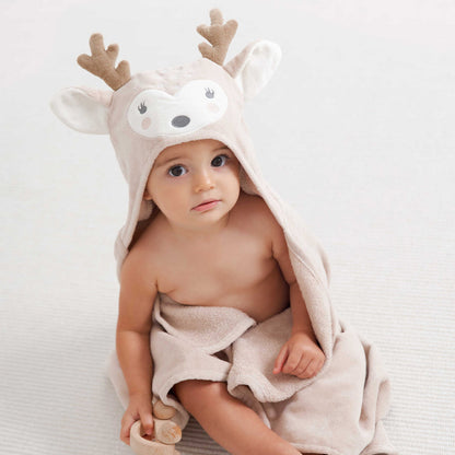 Baby wearing a hooded towel with deer design on a white background