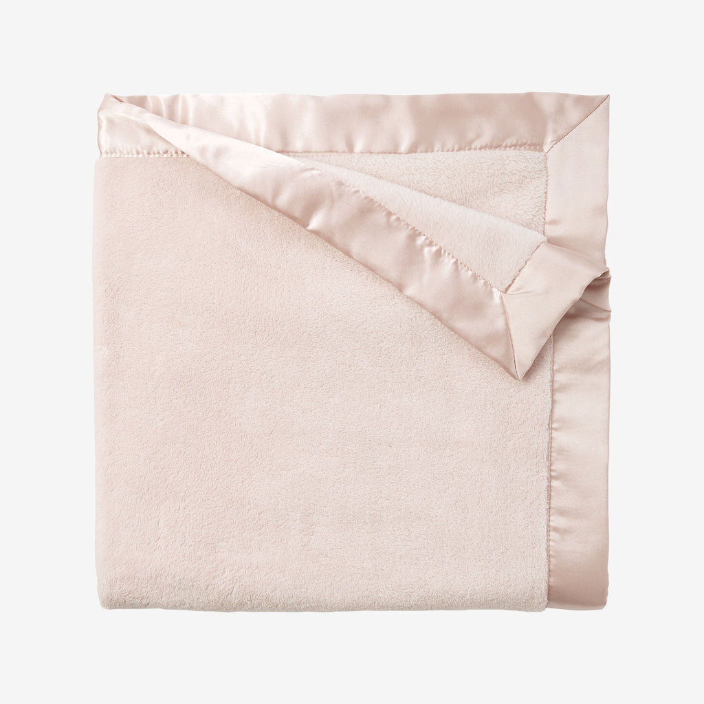 Pink blanket with satin trim on a white background