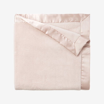 Pink blanket with satin trim on a white background