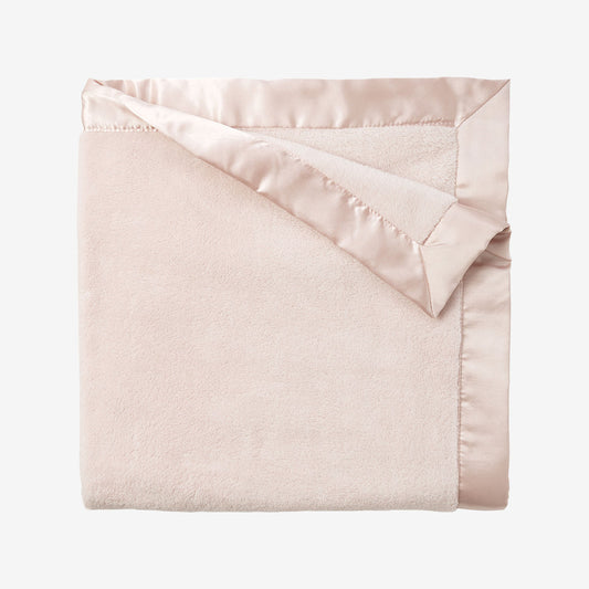Pink blanket with satin trim on a white background