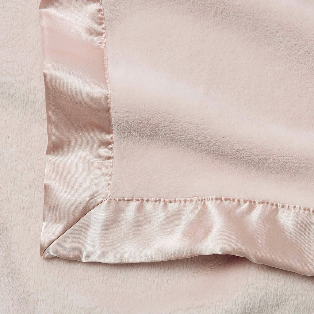 Close-up of a pink satin blanket with a soft texture.