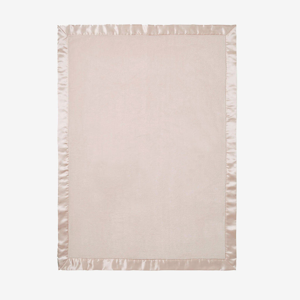 Light pink blanket with satin edge on a white background