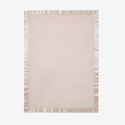 Light pink blanket with satin edge on a white background