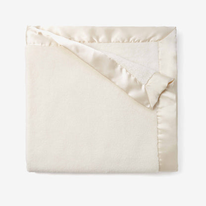 Folded cream blanket on a white background
