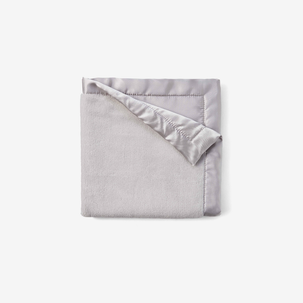 Folded gray blanket with satin edge on a white background