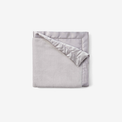 Folded gray blanket with satin edge on a white background