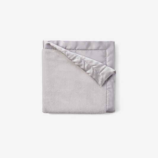 Folded gray blanket with satin edge on a white background