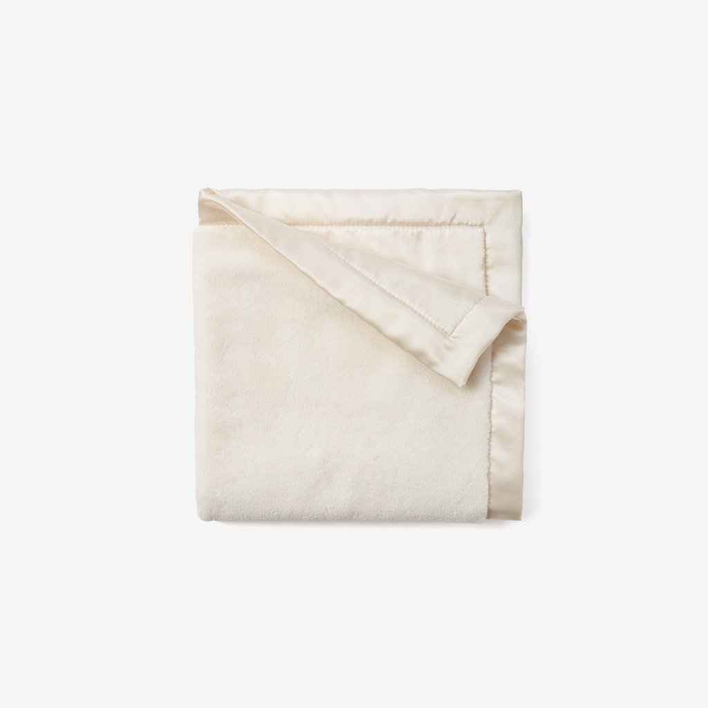Folded cream blanket on a white background