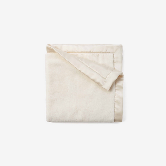 Folded cream blanket on a white background