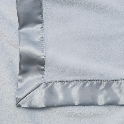 Close-up of a light blue  blanket with satin trim