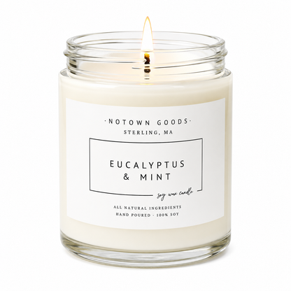Clear jar candle with white wax and a decorative label on a white background.