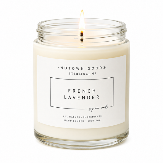 Clear jar candle with white wax and a decorative label on a white background.