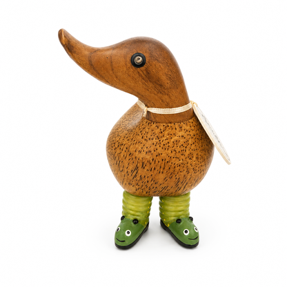 Wooden duck figurine with green shoes on a white background