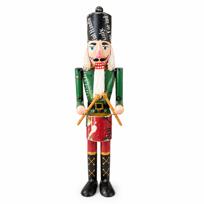Nutcracker soldier with green uniform and red shoes on a white background