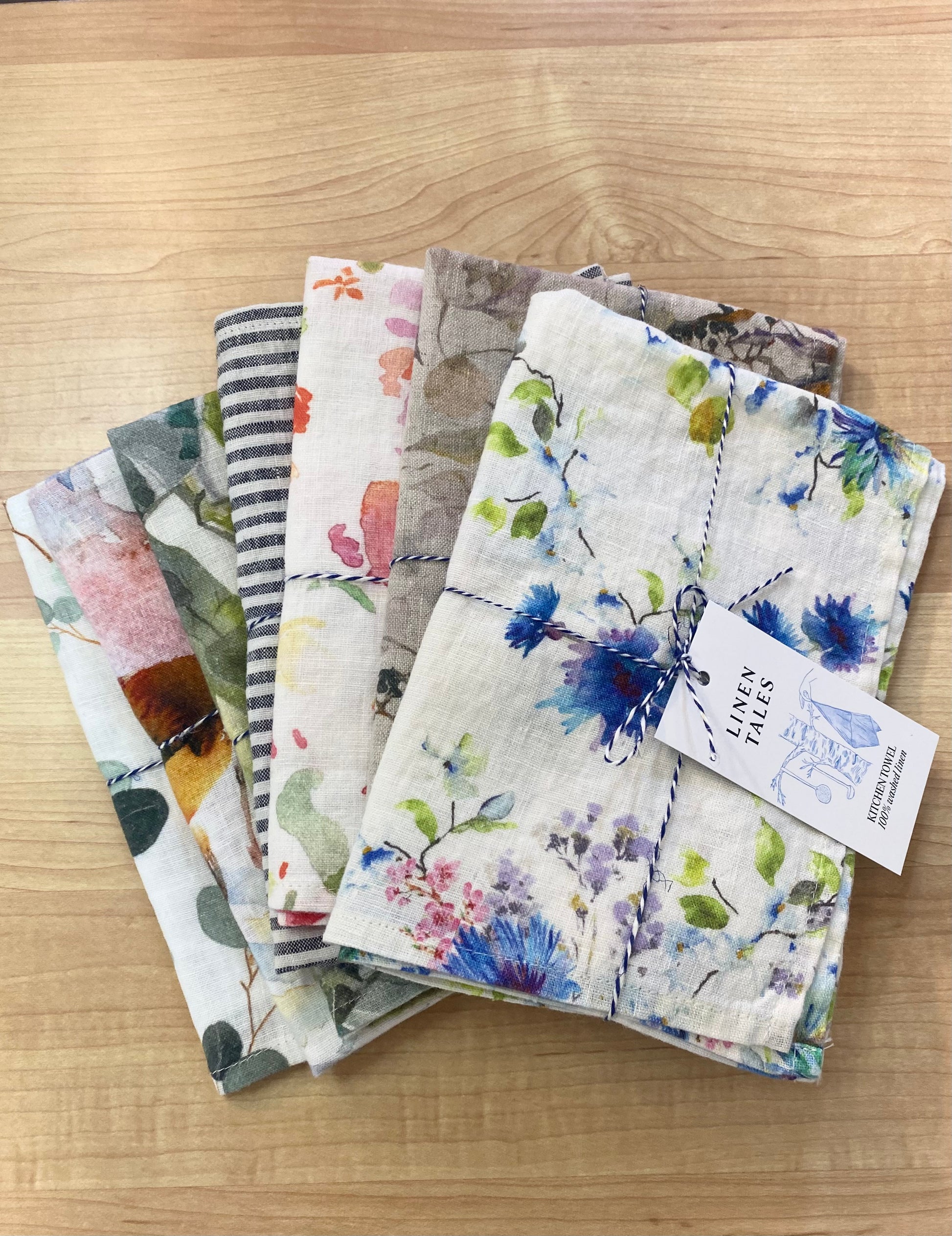 Stack of tea towels on wooden background.