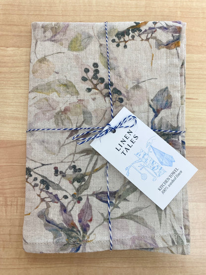 Floral patterned tea towel on wooden background.