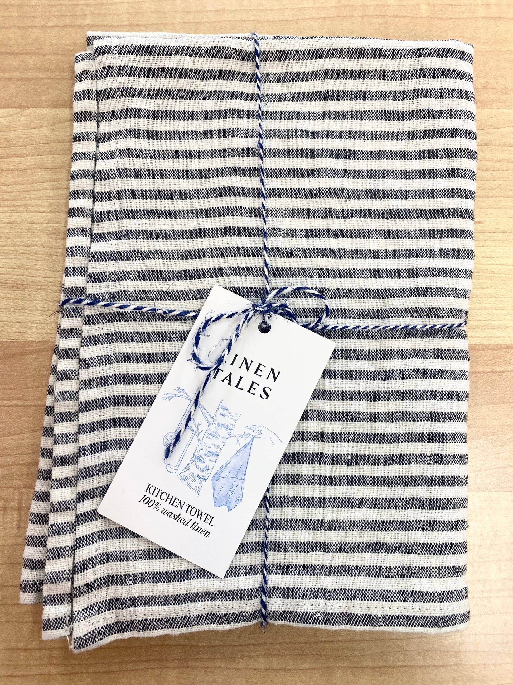 Striped tea towel on wooden background.