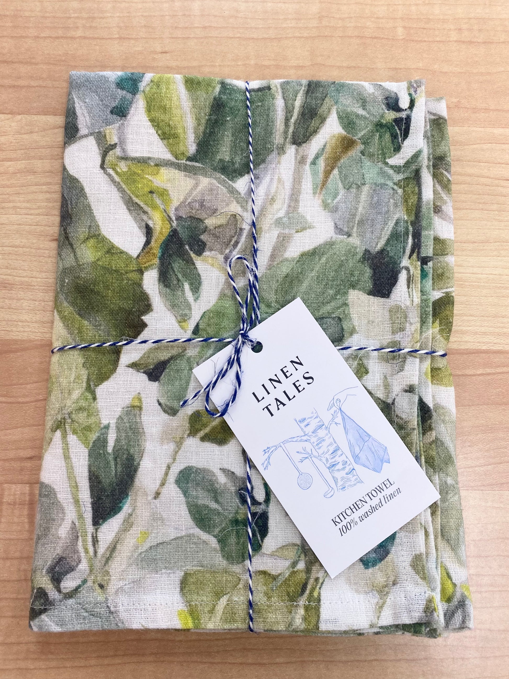 Floral patterned tea towel on wooden background.