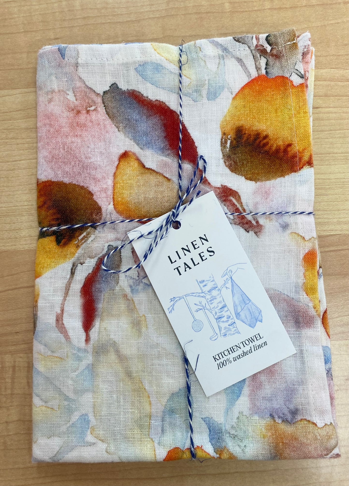 Floral patterned tea towel on wooden background.