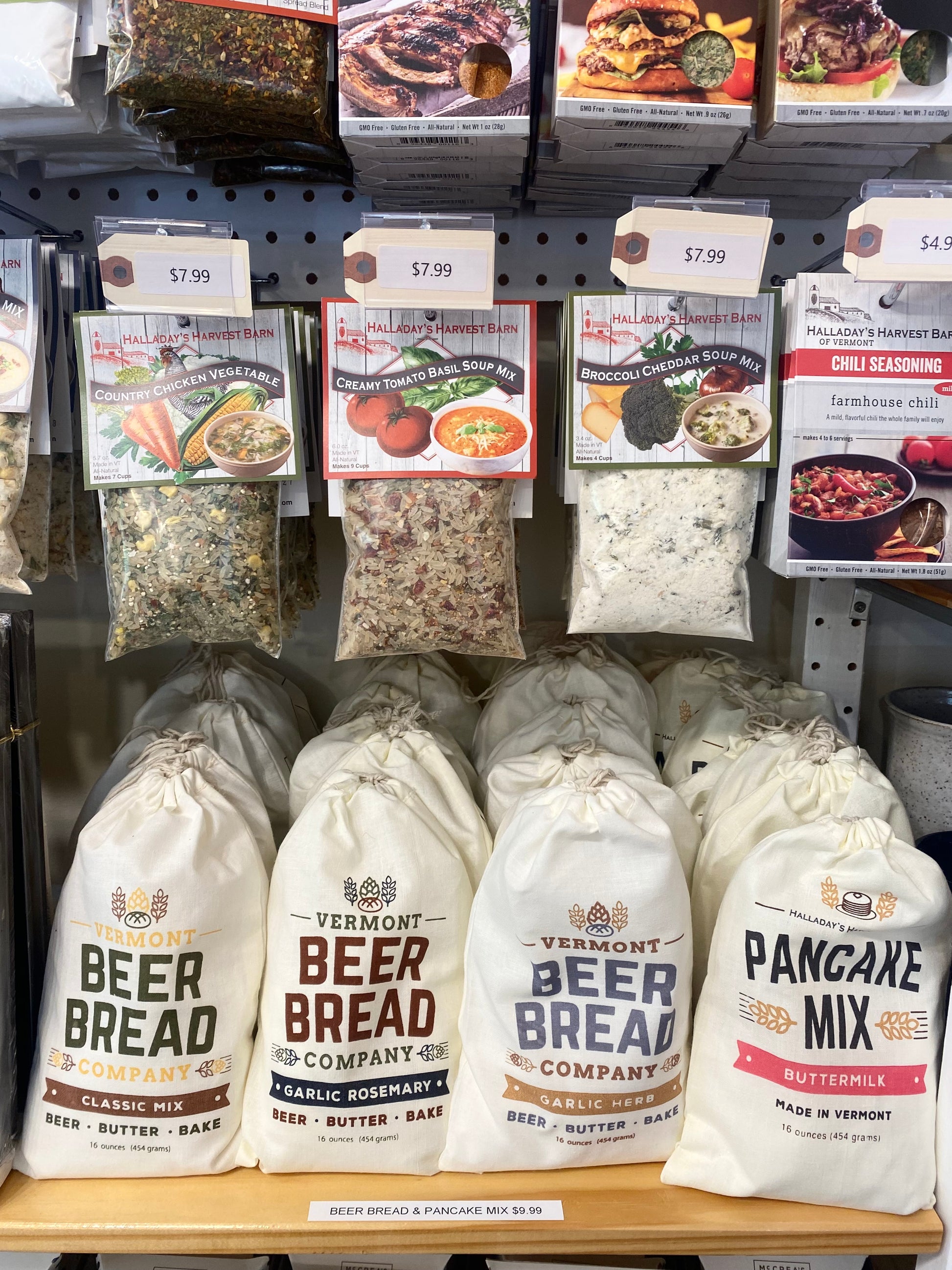 Display of Vermont Beer Bread Company and Halladay's Harvest Barn products including bags and boxes on a shelf.