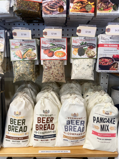 Display of Vermont Beer Bread Company and Halladay's Harvest Barn products including bags and boxes on a shelf.