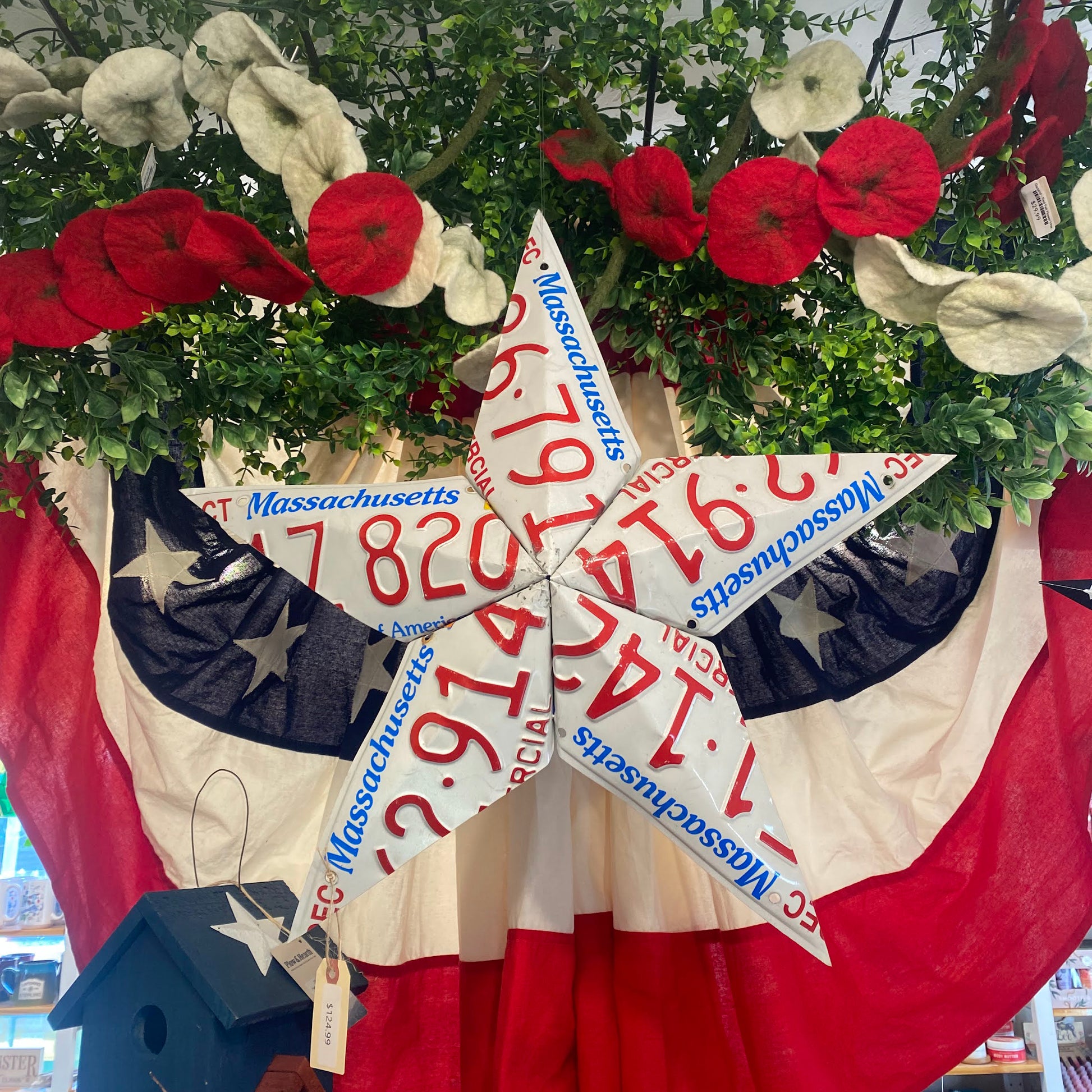 Decorative star with Massachusetts license plates and American flag background.