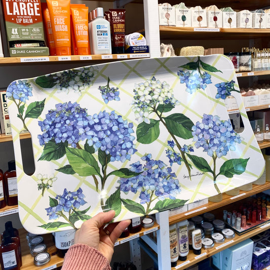 Floral-patterned tray held in a store setting with shelves in the background
