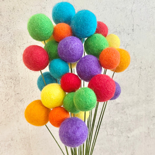 Colorful felt ball bouquet on a textured beige background