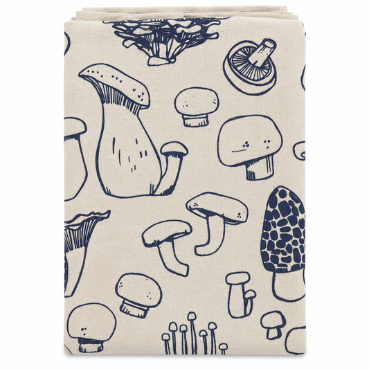 A cream colored tea towel with navy blue mushroom design on a white background.