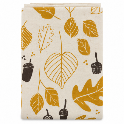 Cream tea towel with acorn and leaves design printed in brown and gold on a white background.