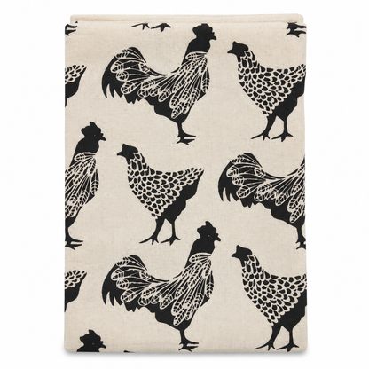 A cream colored tea towel with chicken design printed in black on a white background.