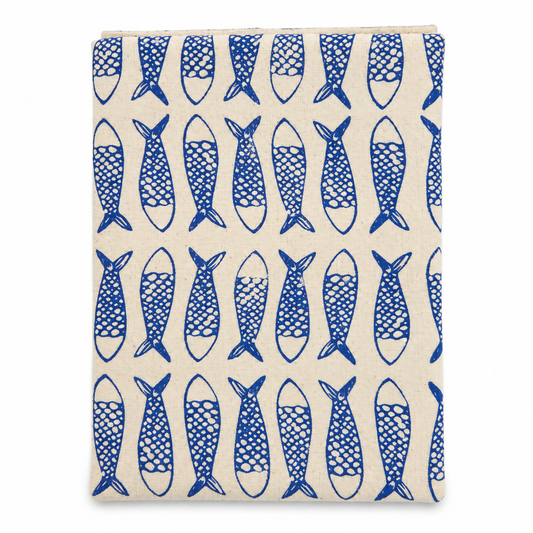 A cream colored tea towel with fish design printed in blue on a white background.