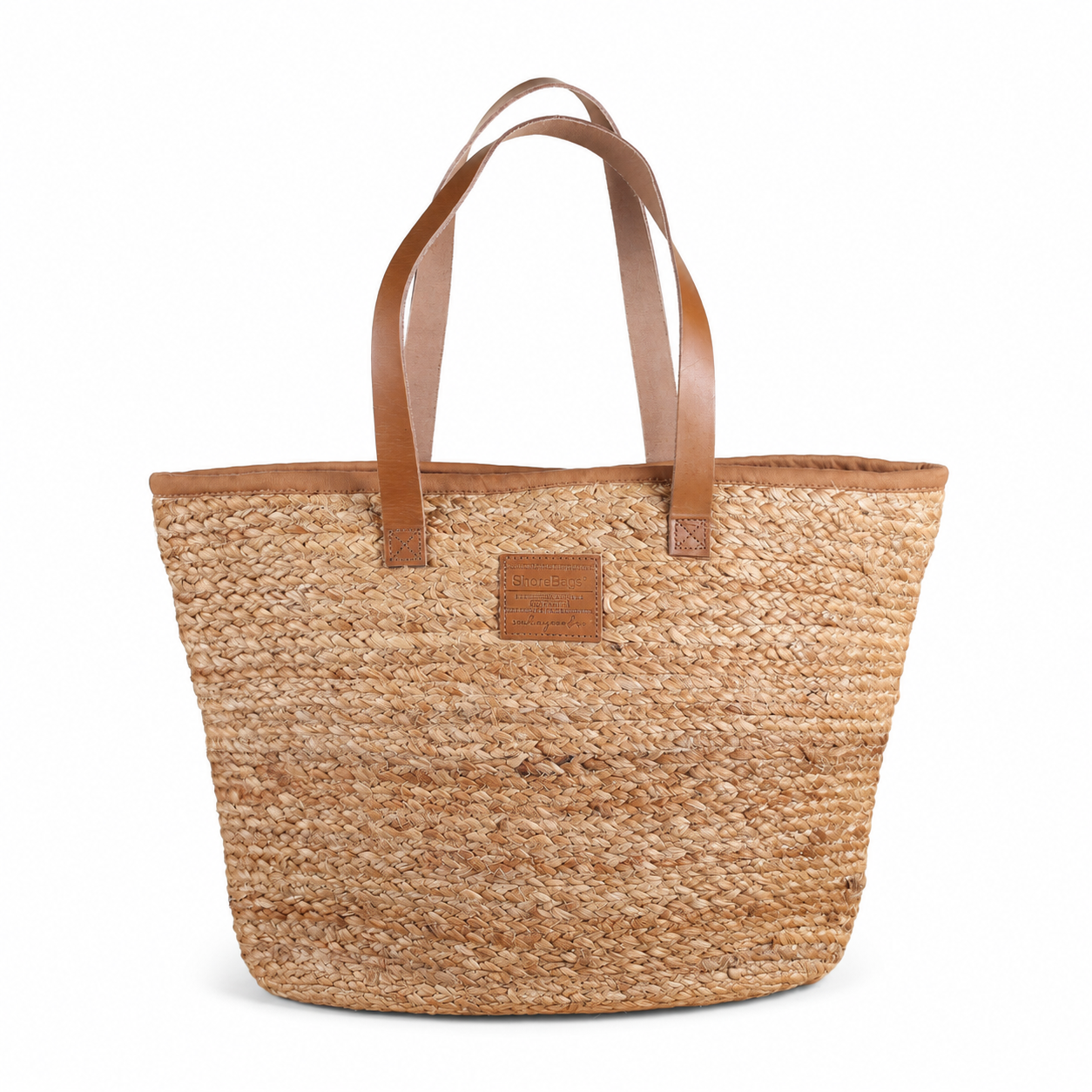Woven tote bag with brown leather handles on a white background