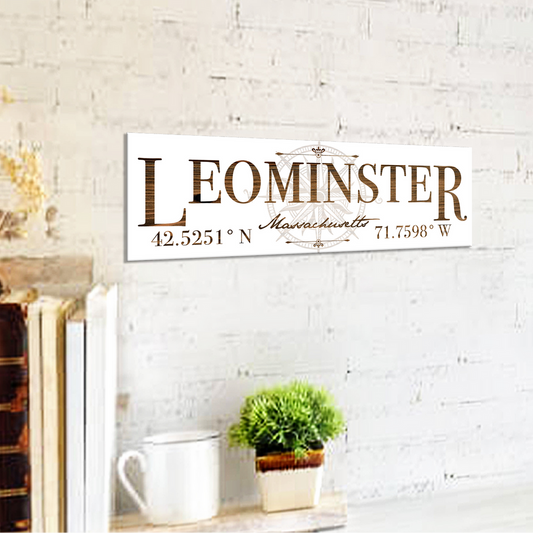 Decorative sign with 'Leominster, Massachusetts' text on a white brick wall background