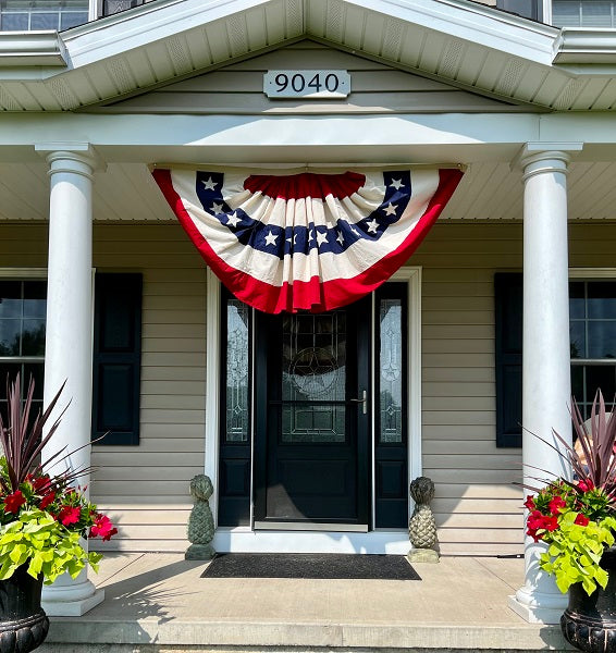 Decorative American flag banner hanging above a front door of a house.