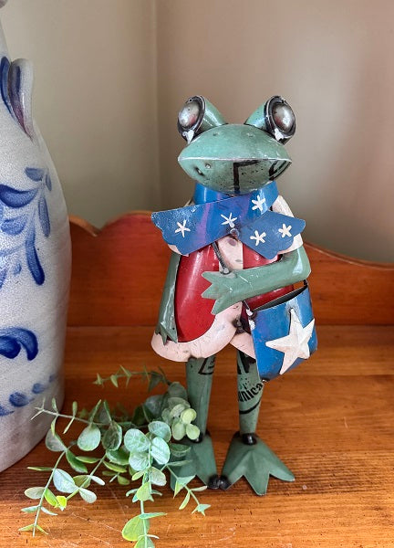 Decorative frog figurine with American flag design on a wooden surface