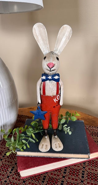Decorative rabbit figurine with red overalls and a blue star on a book