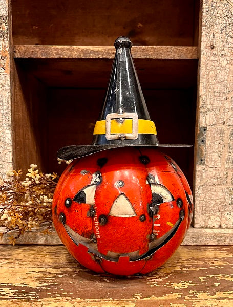 Decorative pumpkin with witch hat on a wooden surface