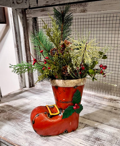 Decorative boot filled with greenery and berries on a wooden surface