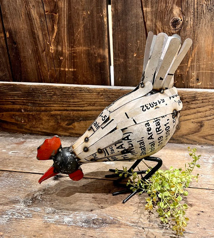 Decorative rooster made from recycled materials on a wooden surface