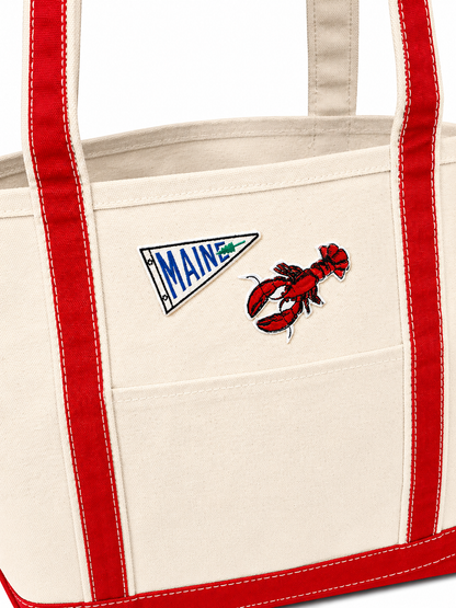 Tote bag with 'MAINE' emblem and lobster design on a white background