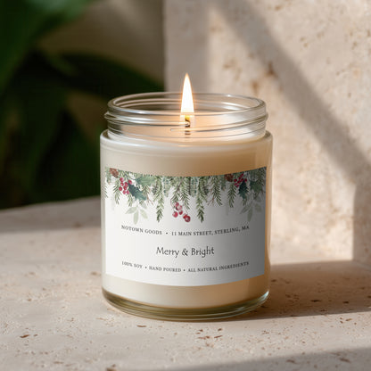 Clear jar candle with white wax and a decorative label on a blurred outdoor background.